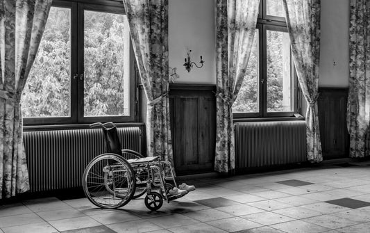 Black and white photo of a room with a wheel chair