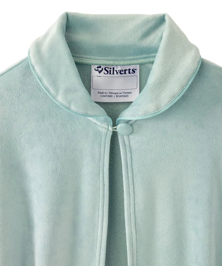 Close-up view of the baby blue sleep cape's collar, displaying the Silverts brand label and the secure button closure for easy dressing