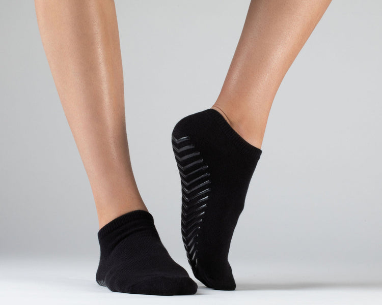 Model wearing black anti slip ankle socks made of ultra soft cotton with sticky grips.