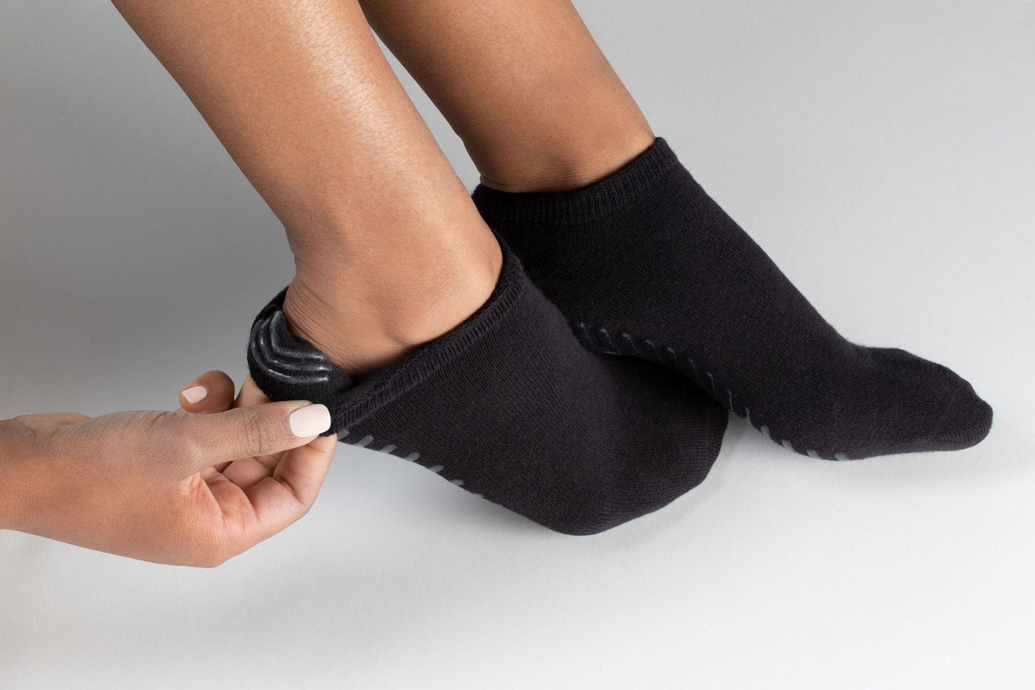 Model wearing black anti slip ankle socks made of ultra soft cotton with sticky grips.