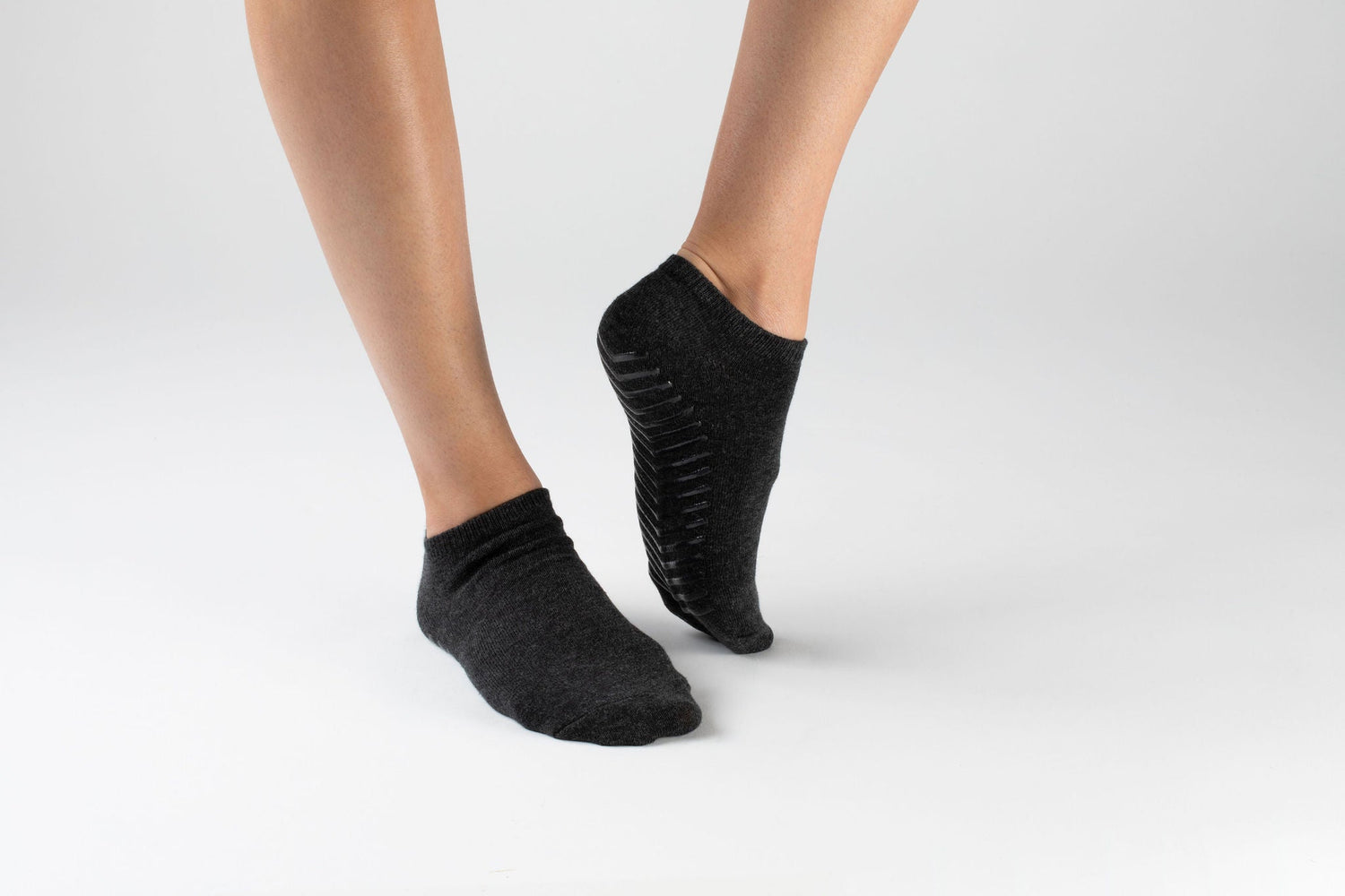 Model wearing black anti slip ankle socks made of ultra soft cotton with sticky grips.