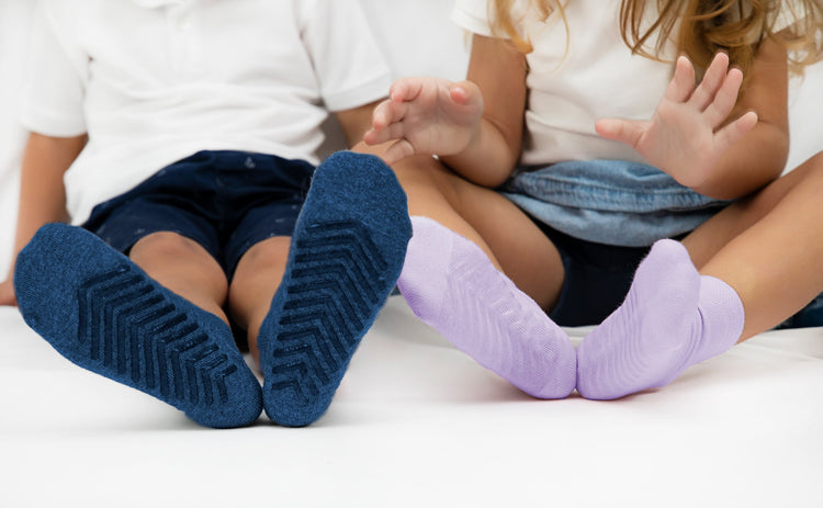 Children wearing anti slip socks with tread pattern on the bottom.