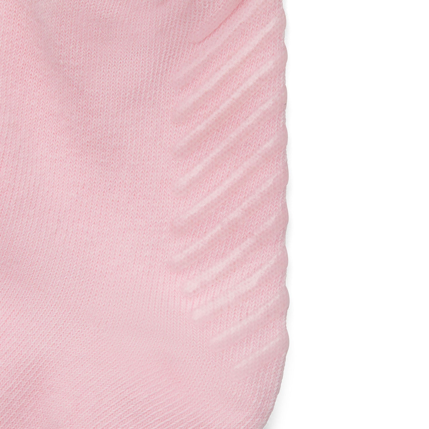 Close up of light pink anti slip kids socks with tread pattern on the bottom.