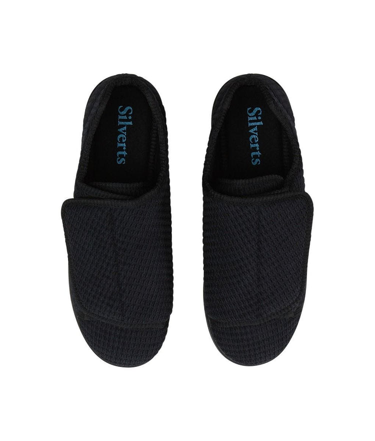 Top of extra wide black indoor slippers feature huge velcro closures to open slipper completely