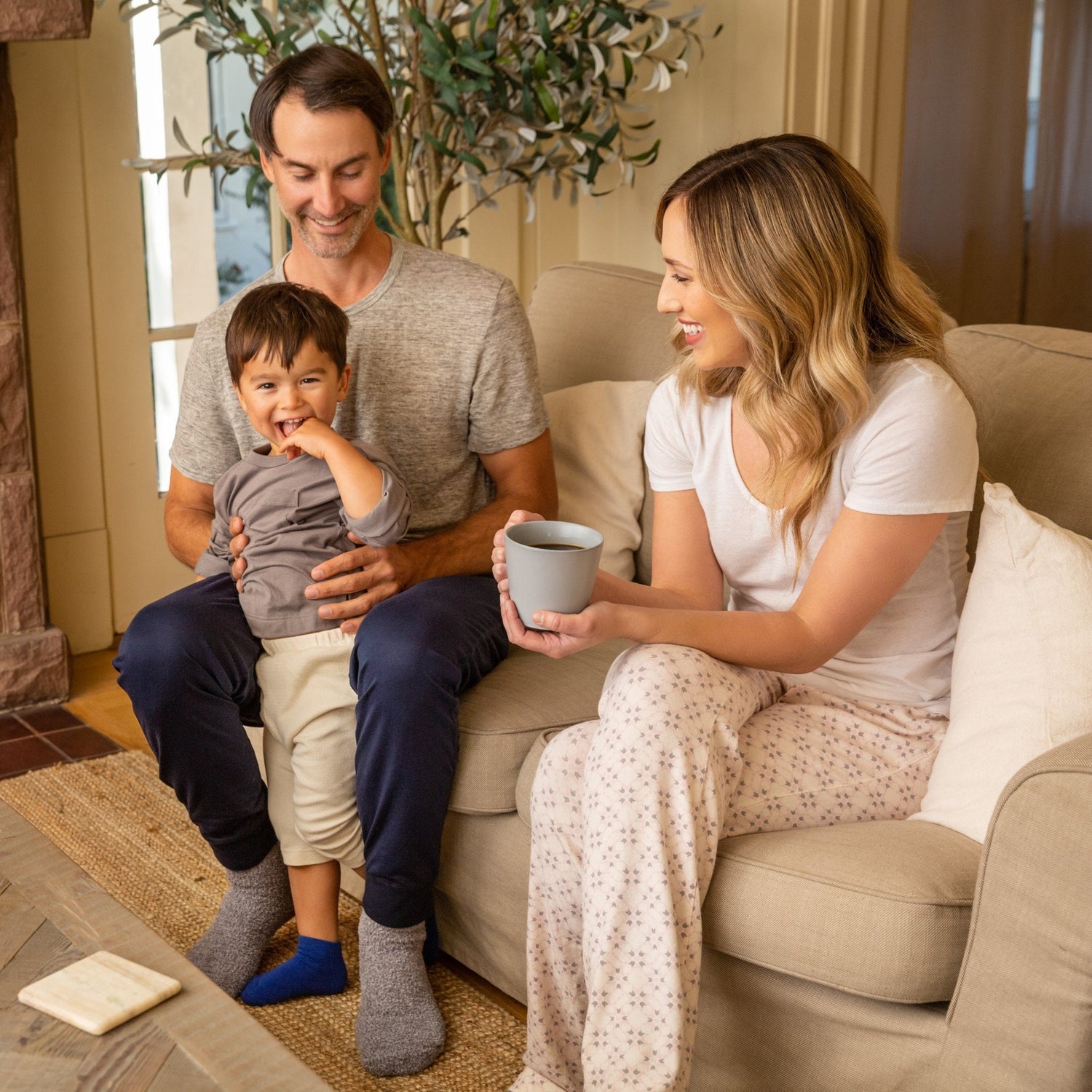 Family smiling wearing anti slip socks with tread pattern on the bottom.