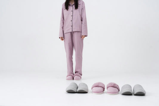Women in her pyjamas alongside 3 pairs of comfortable sleeping shoes