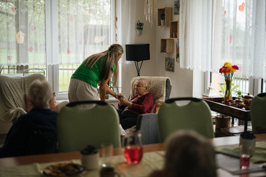 Women holding elderly man's hand