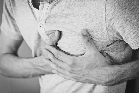 Black and white photos of a man holding his chest