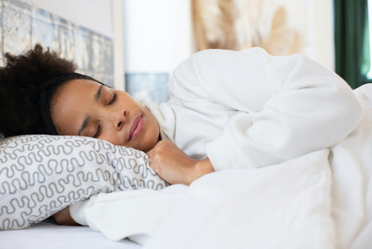 Women sleeping in a all white bed wearing all white.