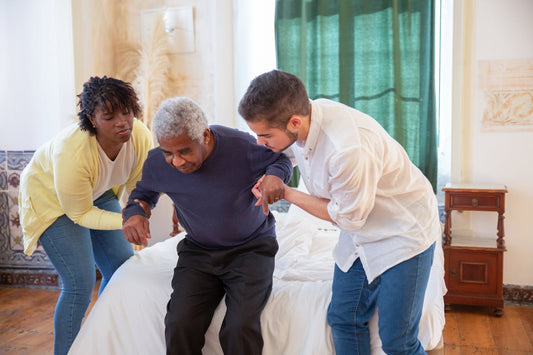 two people helping an elderly man stand up