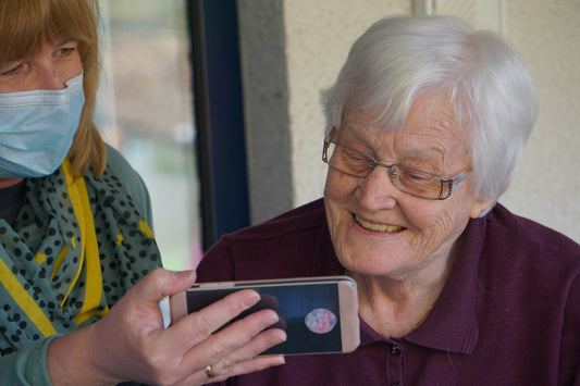 Woman showing phone to elderly woman