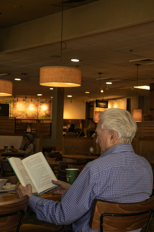 Elderly man at a table reading