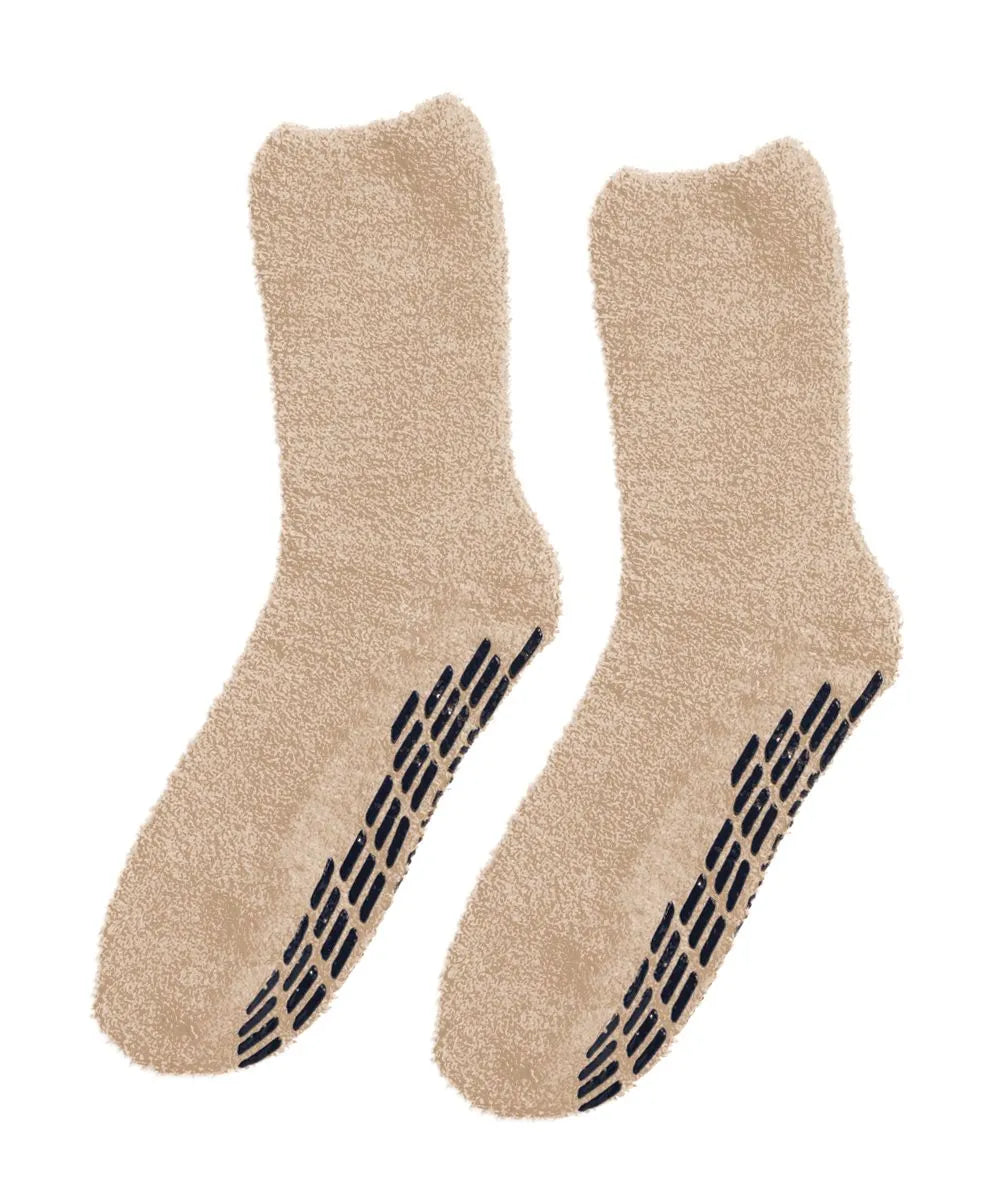 beige fuzzy socks, shown from the side, highlighting the plush texture and non-slip pattern on the sole.