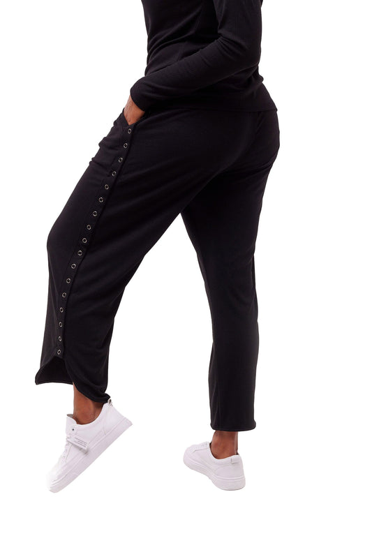 Woman wearing black flowy wide leg pants with side seam snap closures.