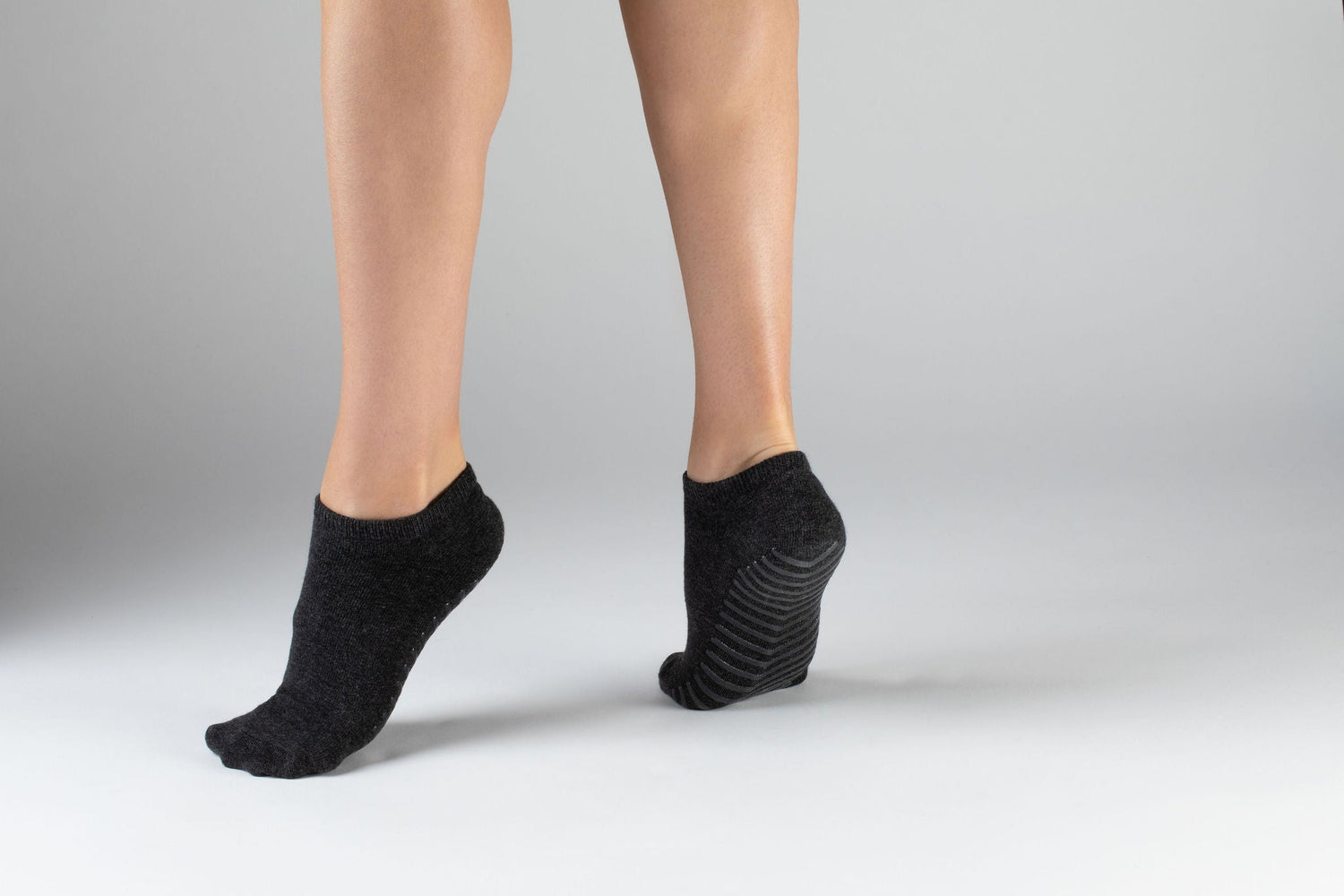 Model wearing black anti slip ankle socks made of ultra soft cotton with sticky grips.