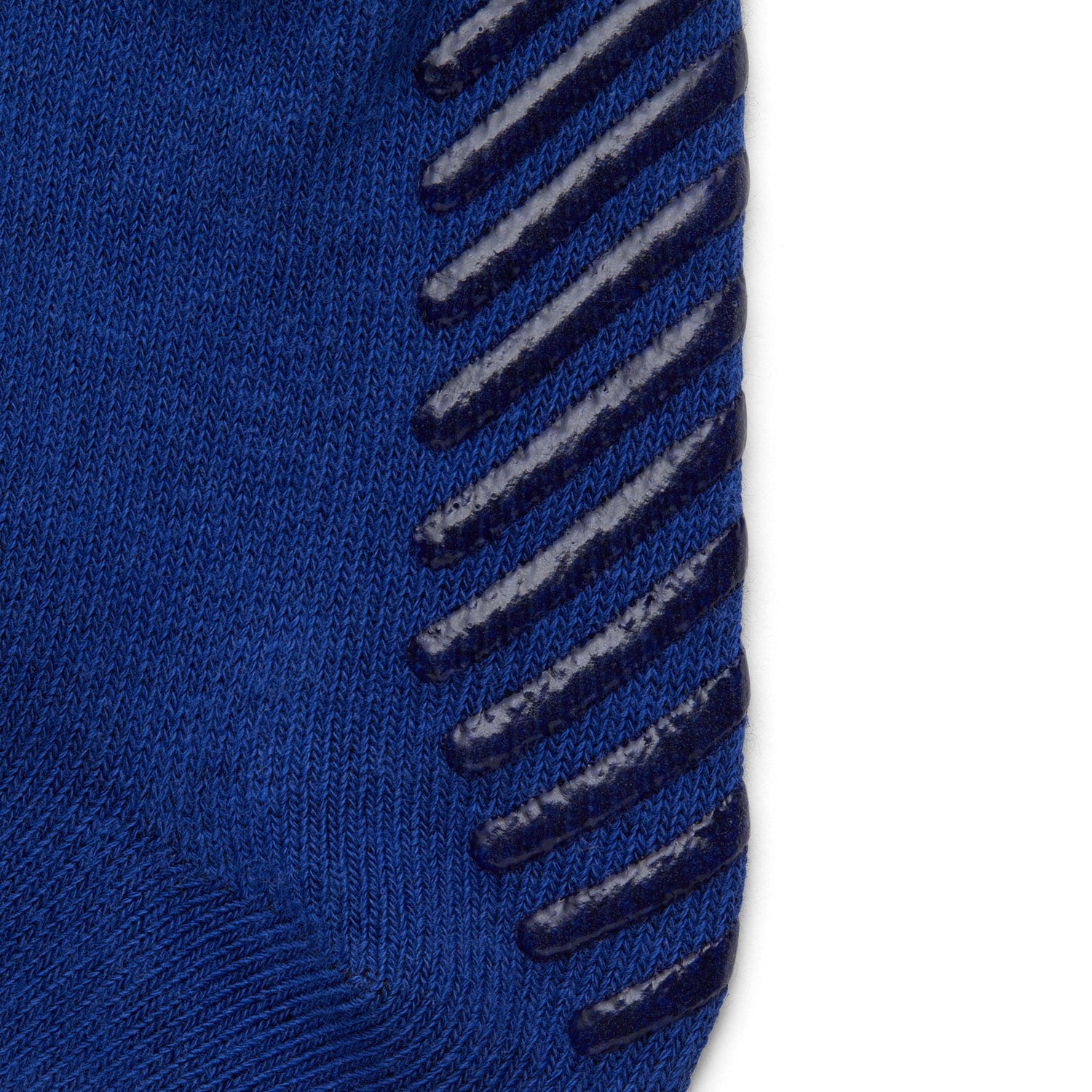 Close up of blue anti slip kids socks with tread pattern on the bottom.