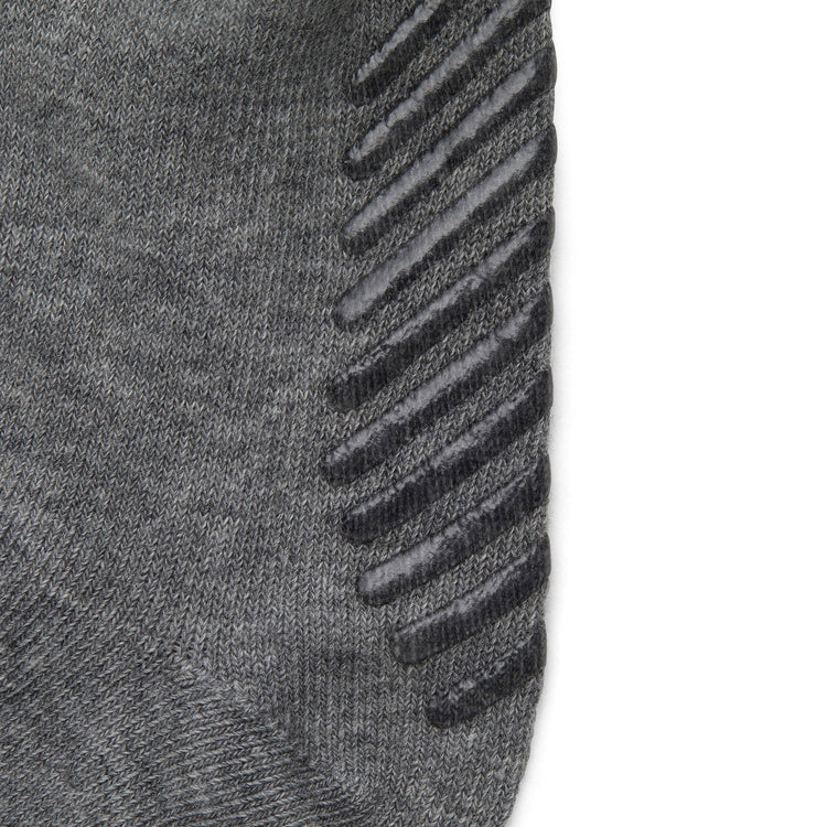 Close up of light grey anti slip kids socks with tread pattern on the bottom.