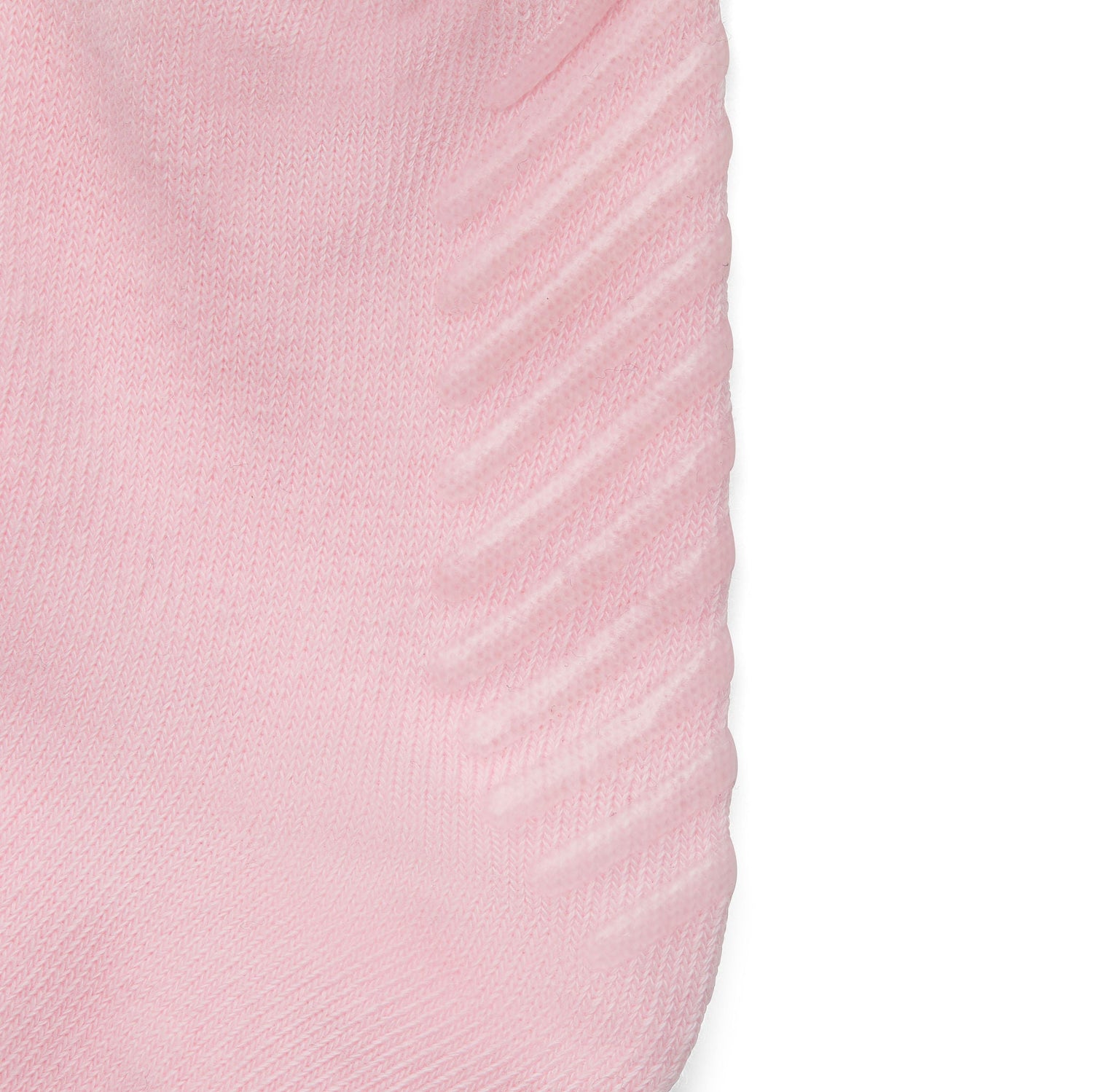 Close up of light pink anti slip kids socks with tread pattern on the bottom.