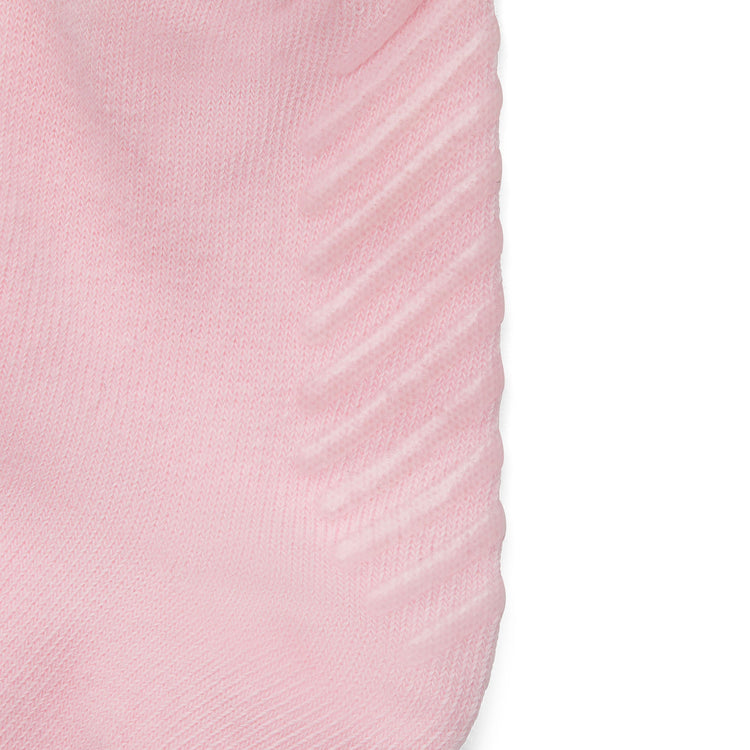 Close up of light pink anti slip kids socks with tread pattern on the bottom.