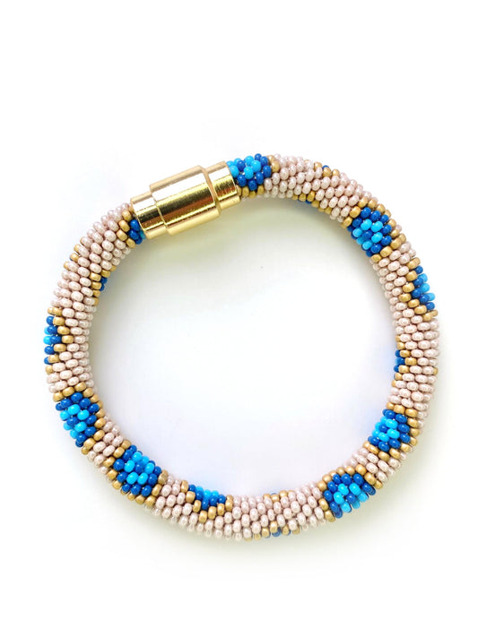 Cream, yellow, and blue bracelet with gold magnetic closure.