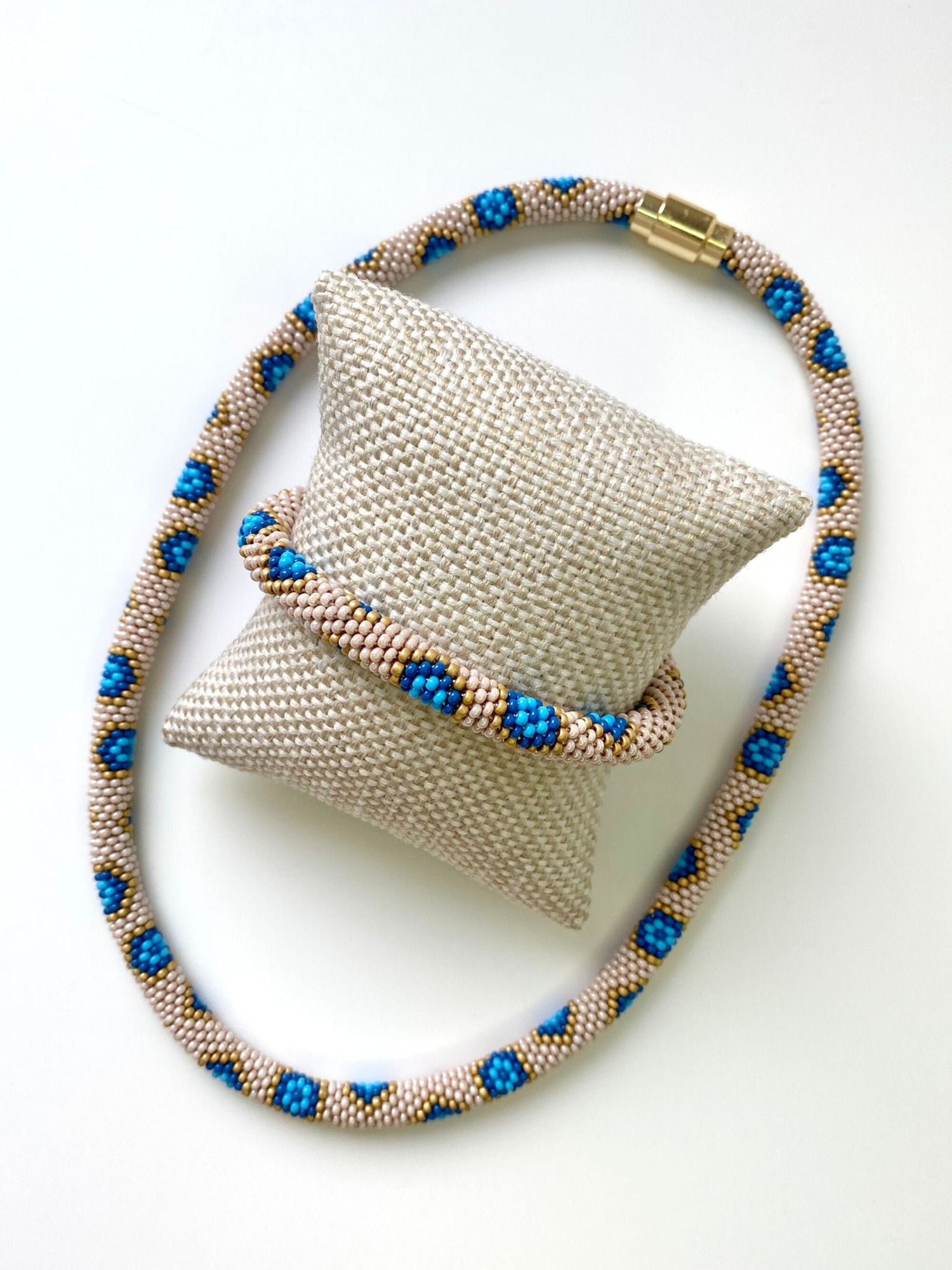 Cream, yellow, and blue bracelet with gold magnetic closure and matching necklace.