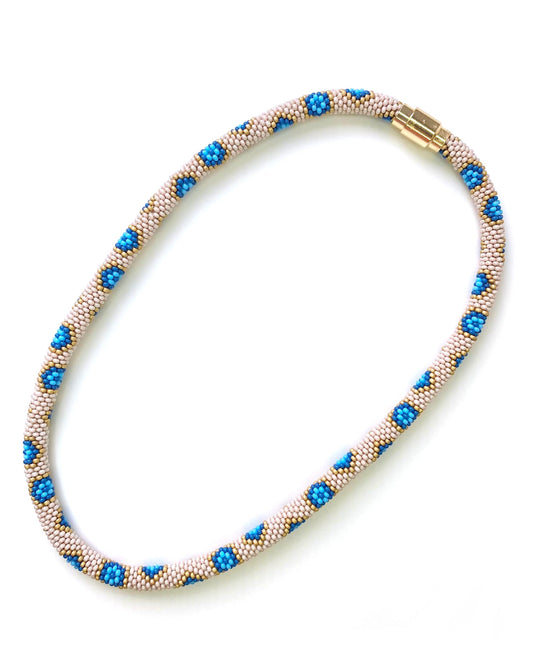 Cream, yellow, and blue necklace with gold magnetic closure.