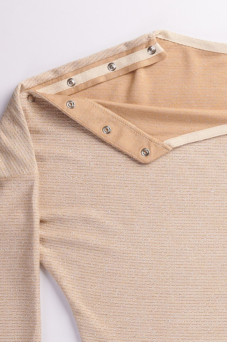 Close up of cream long sleeve top with shoulder snap closures.