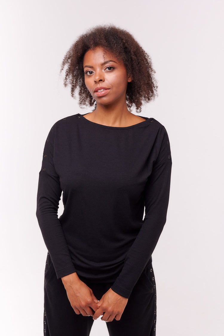 Woman smiling wearing black long sleeve top with shoulder snap closures.