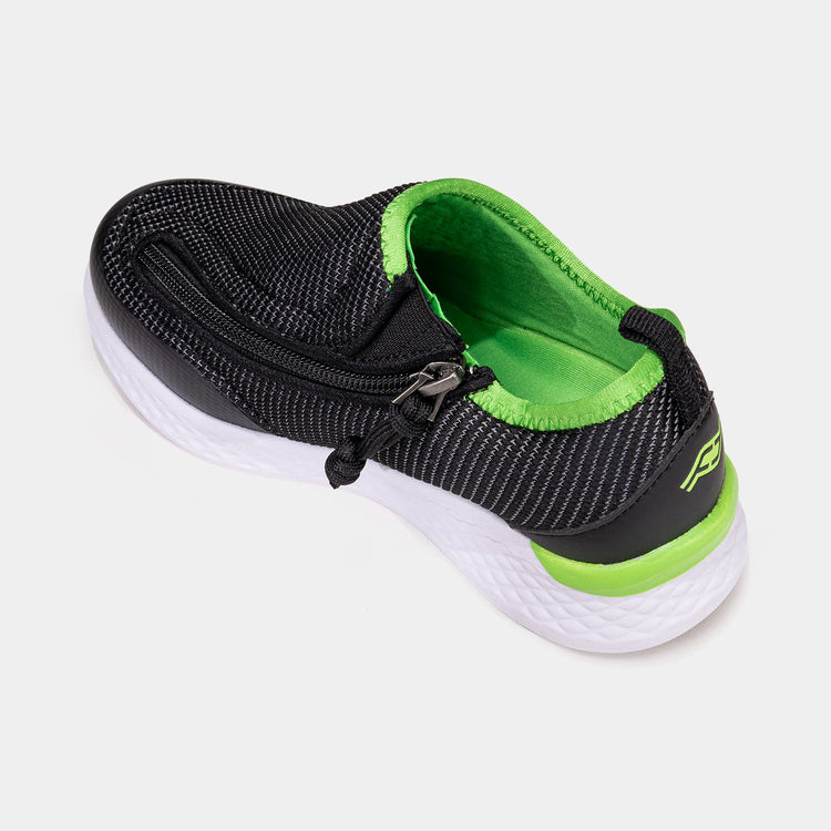 Black kids shoe with white bottom, green accents, and side zipper access.
