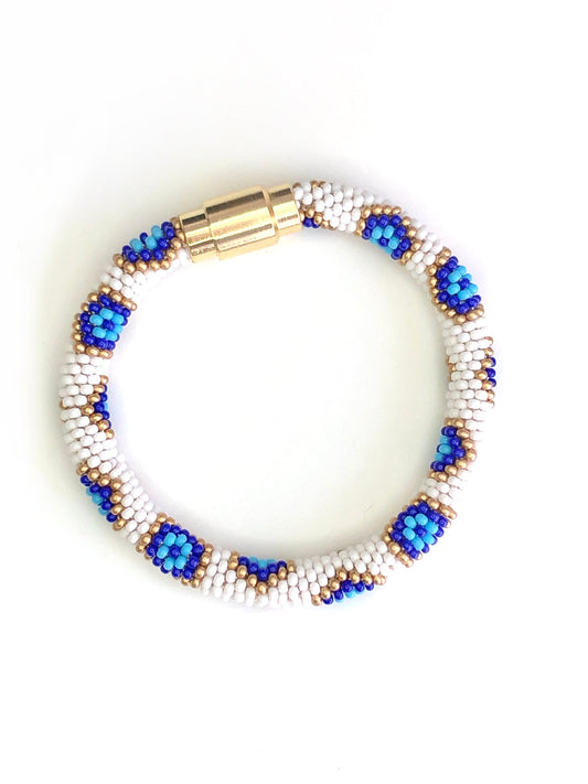 White, blue, and gold bracelet with gold magnetic closure.