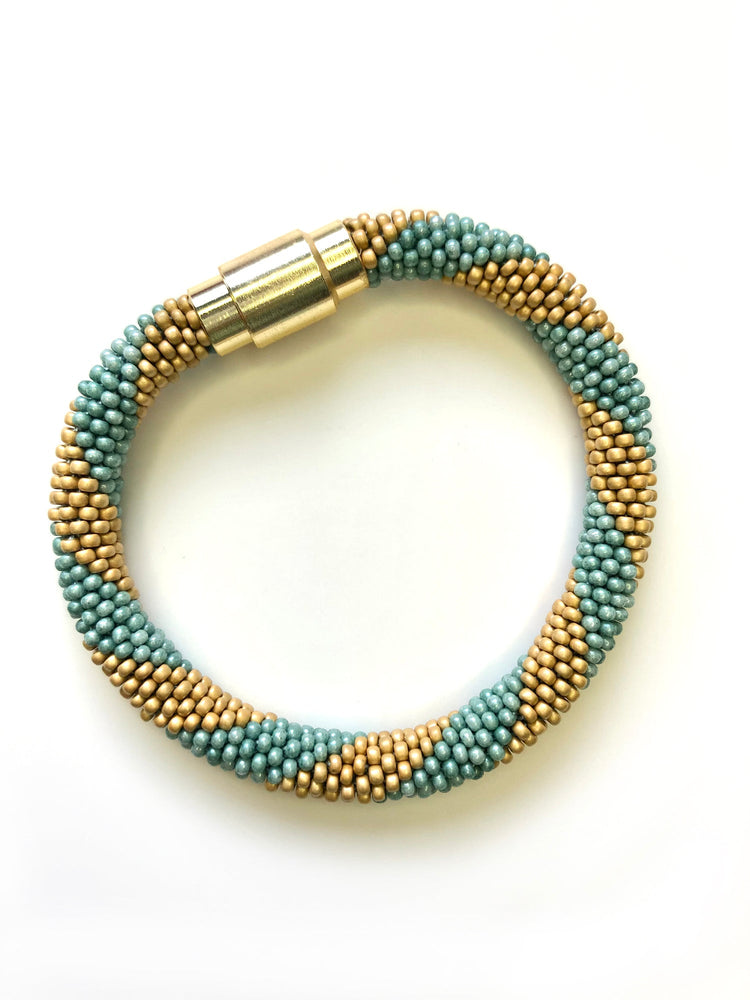 Green and gold bracelet with gold magnetic closure.