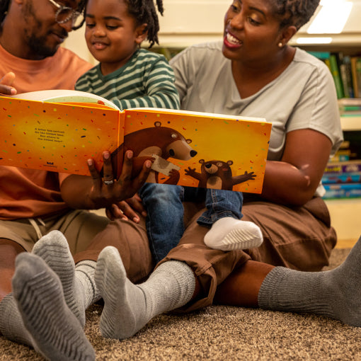 Family wearing light grey anti slip diabetic socks with tread pattern on the bottom.