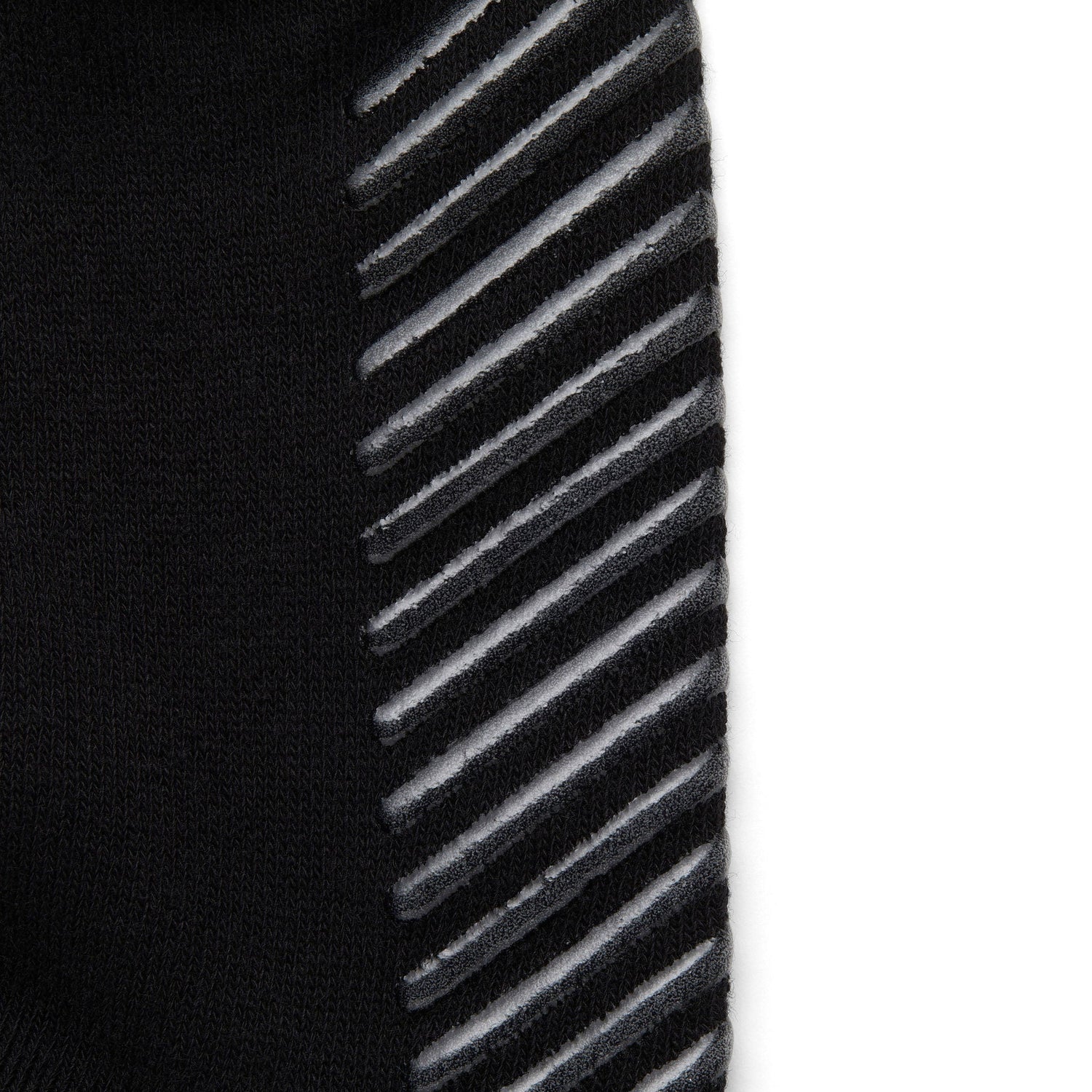 Close up of black anti slip socks with tread pattern on the bottom.
