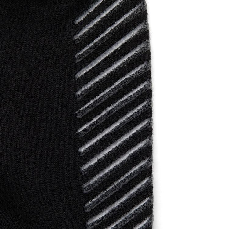 Close up of black anti slip socks with tread pattern on the bottom.