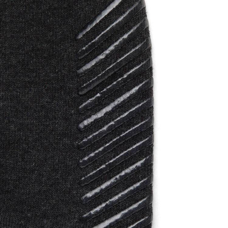 Close up of dark grey anti slip socks with tread pattern on the bottom.