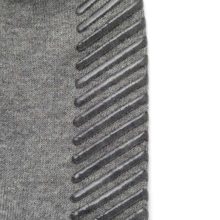 Close up of light grey anti slip socks with tread pattern on the bottom.