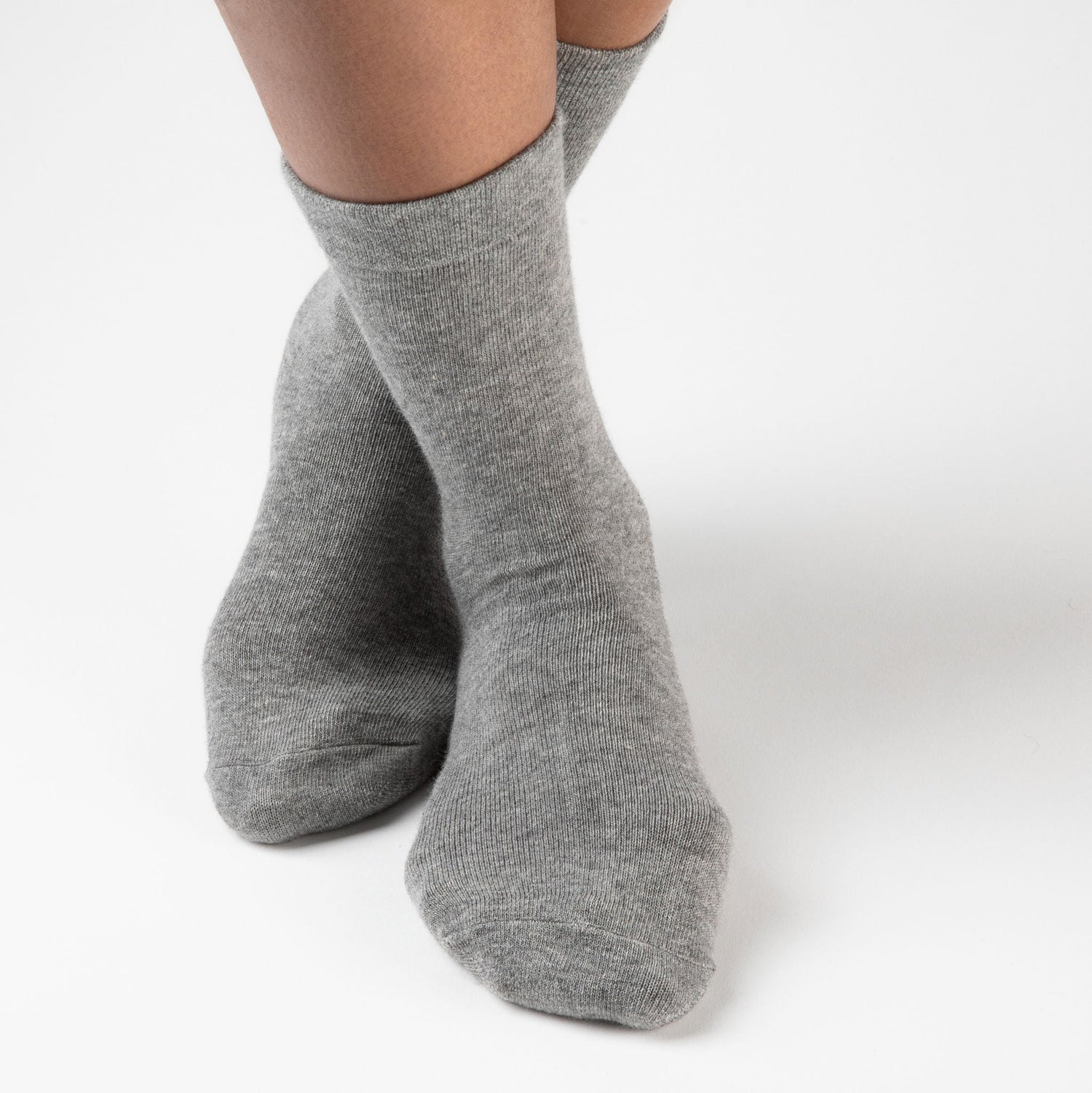 Model wearing light grey anti slip socks made of ultra soft luxury cotton blend.