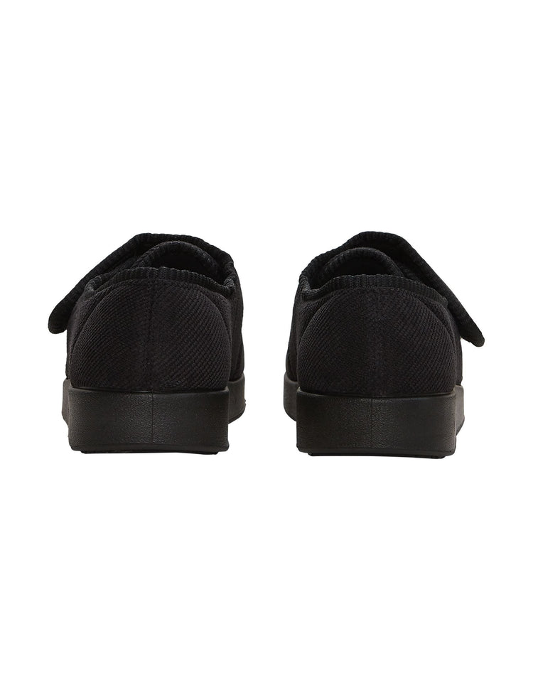 Back of soft and flexible wide black indoor slippers with non slip black soles