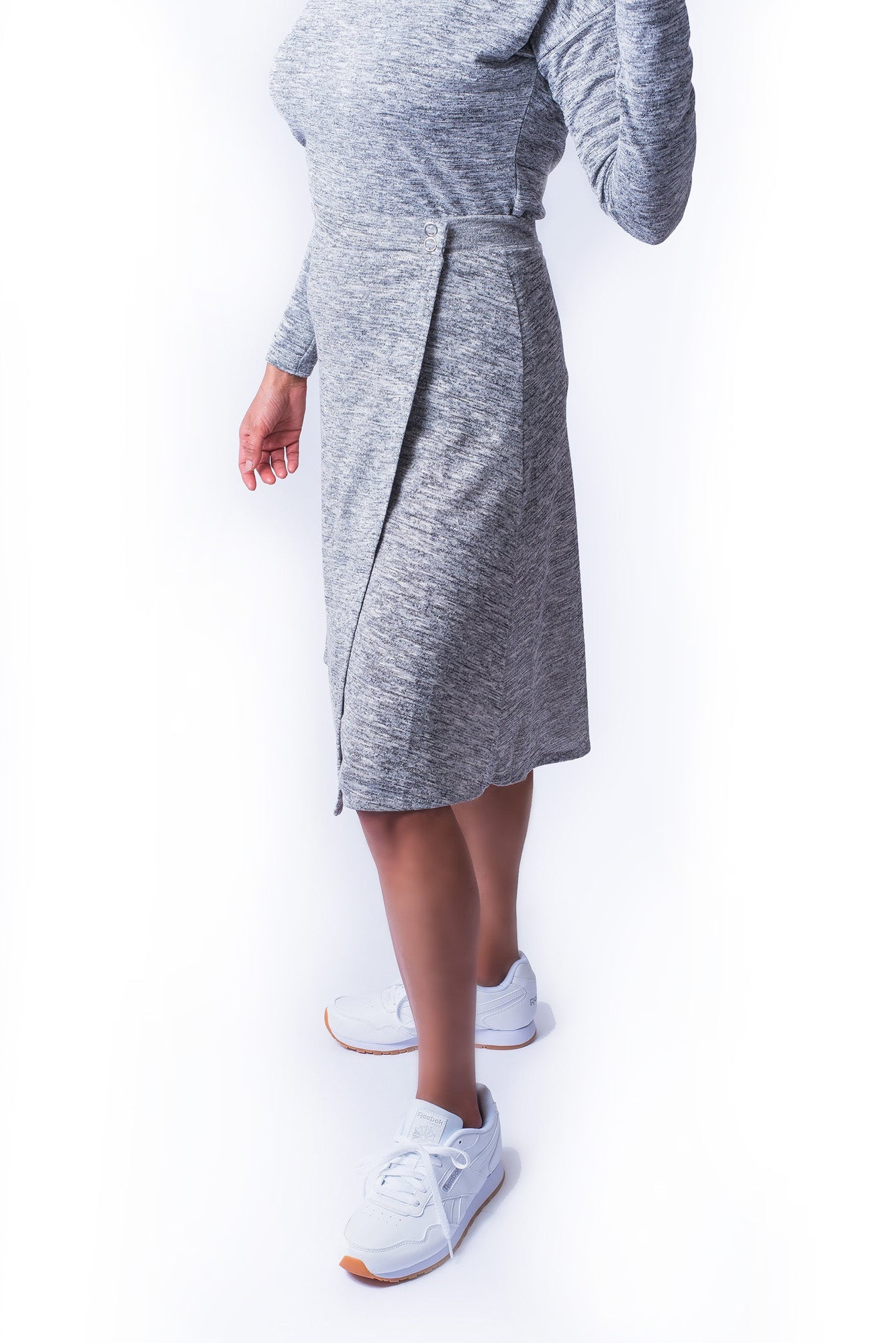 Woman wearing grey wrap skirt with snap closure waist band and matching grey top.