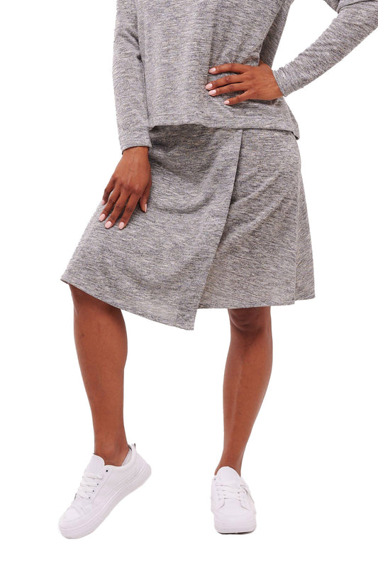 Woman wearing stretchy grey wrap skirt with snap closure waist band.