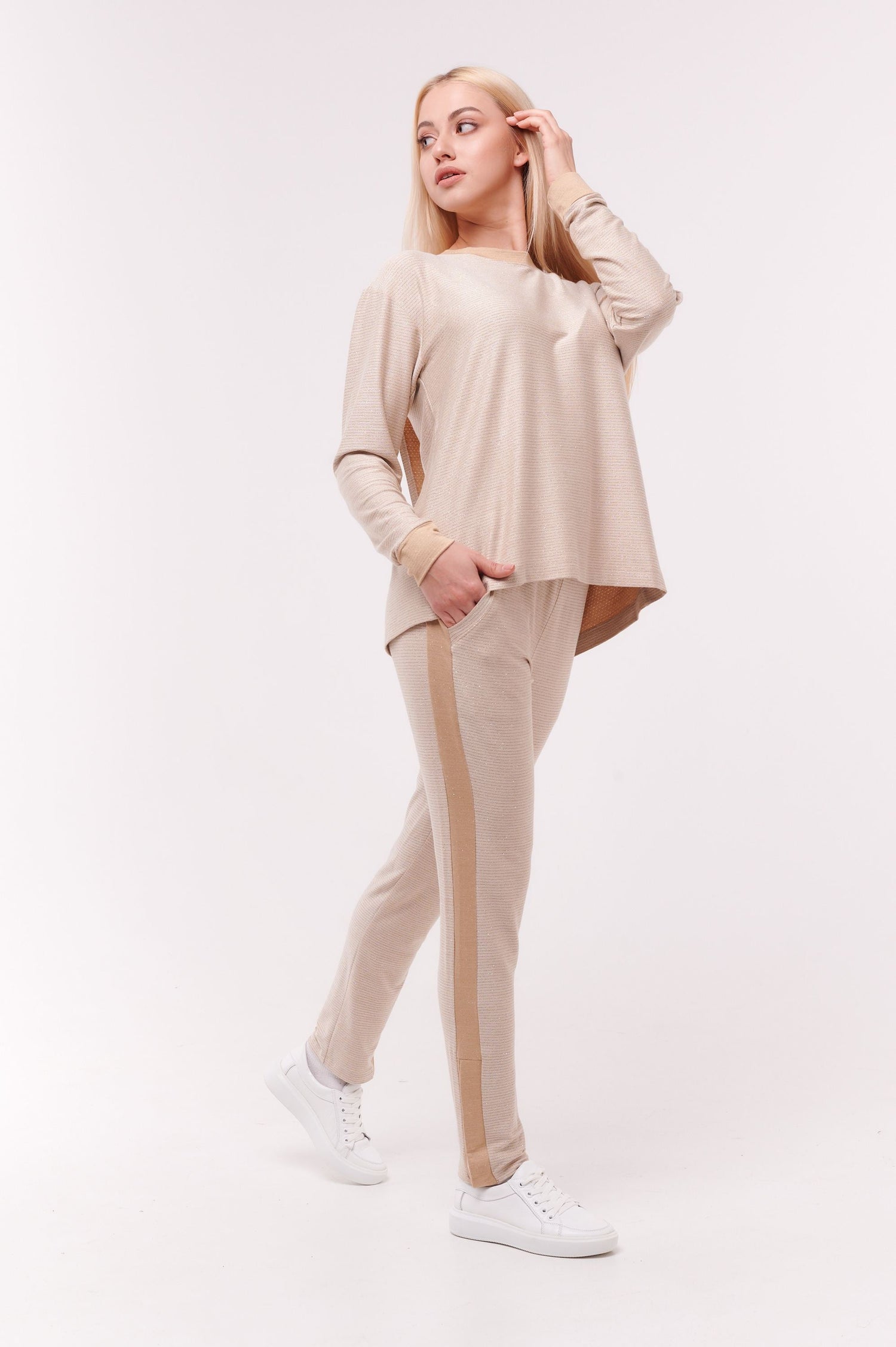 Woman posing wearing cream long sleeve top with back overlap and matching bottoms.