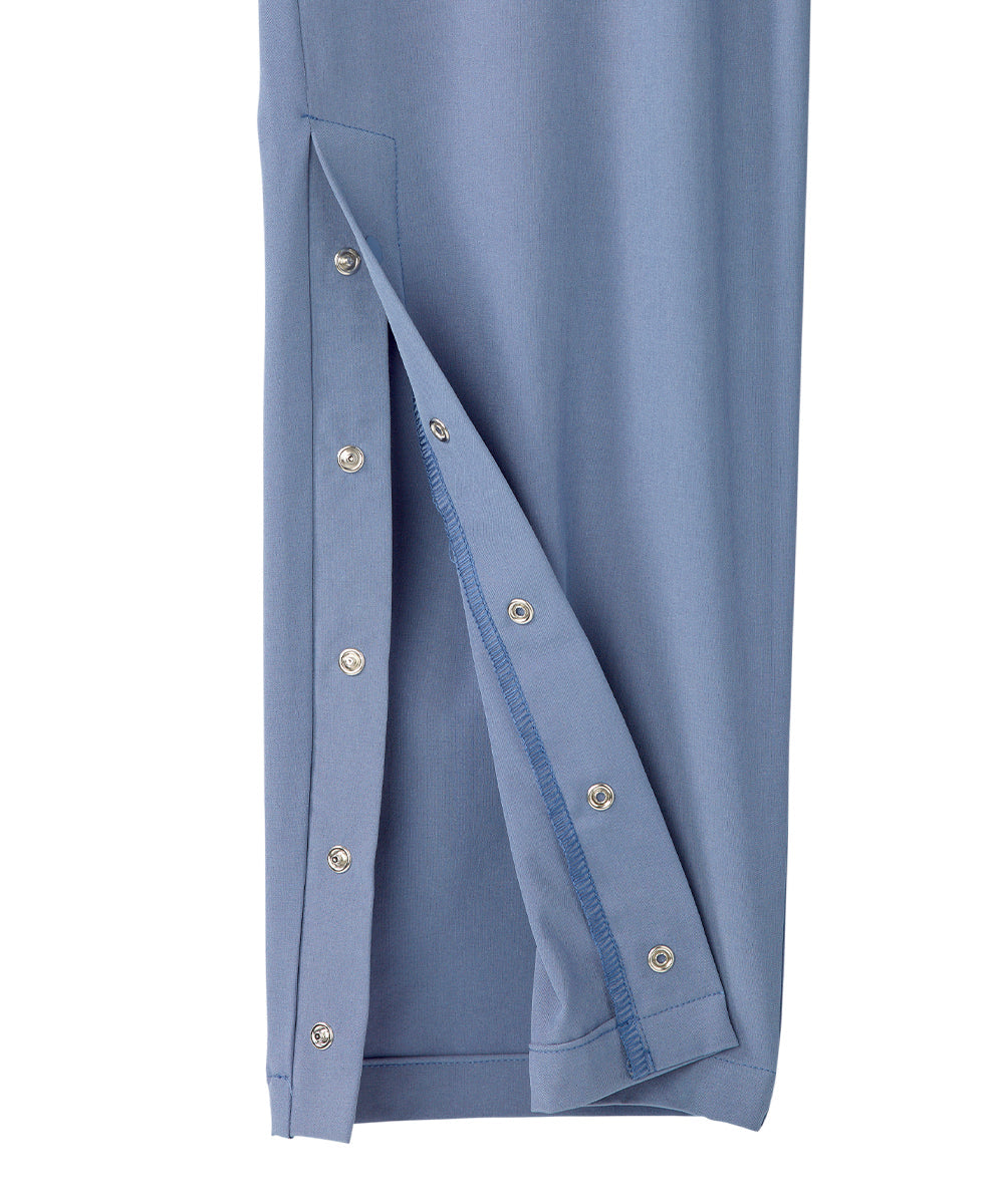 Close up of ankle of women’s light blue pants with snaps along the side seam.