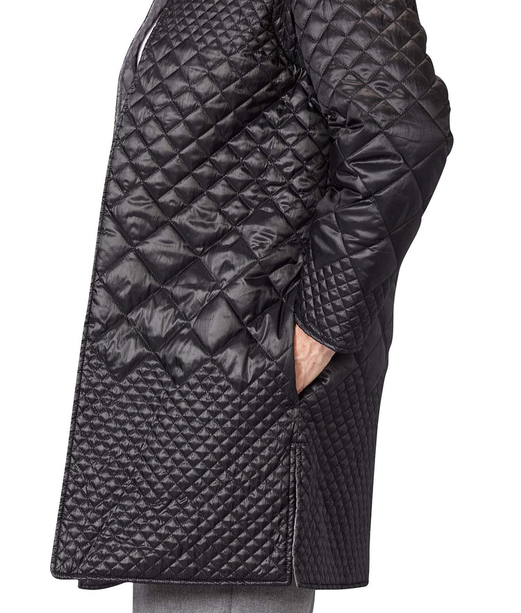 Close up of women’s black quilted reversible jacket with side seam pockets and removable sleeves.