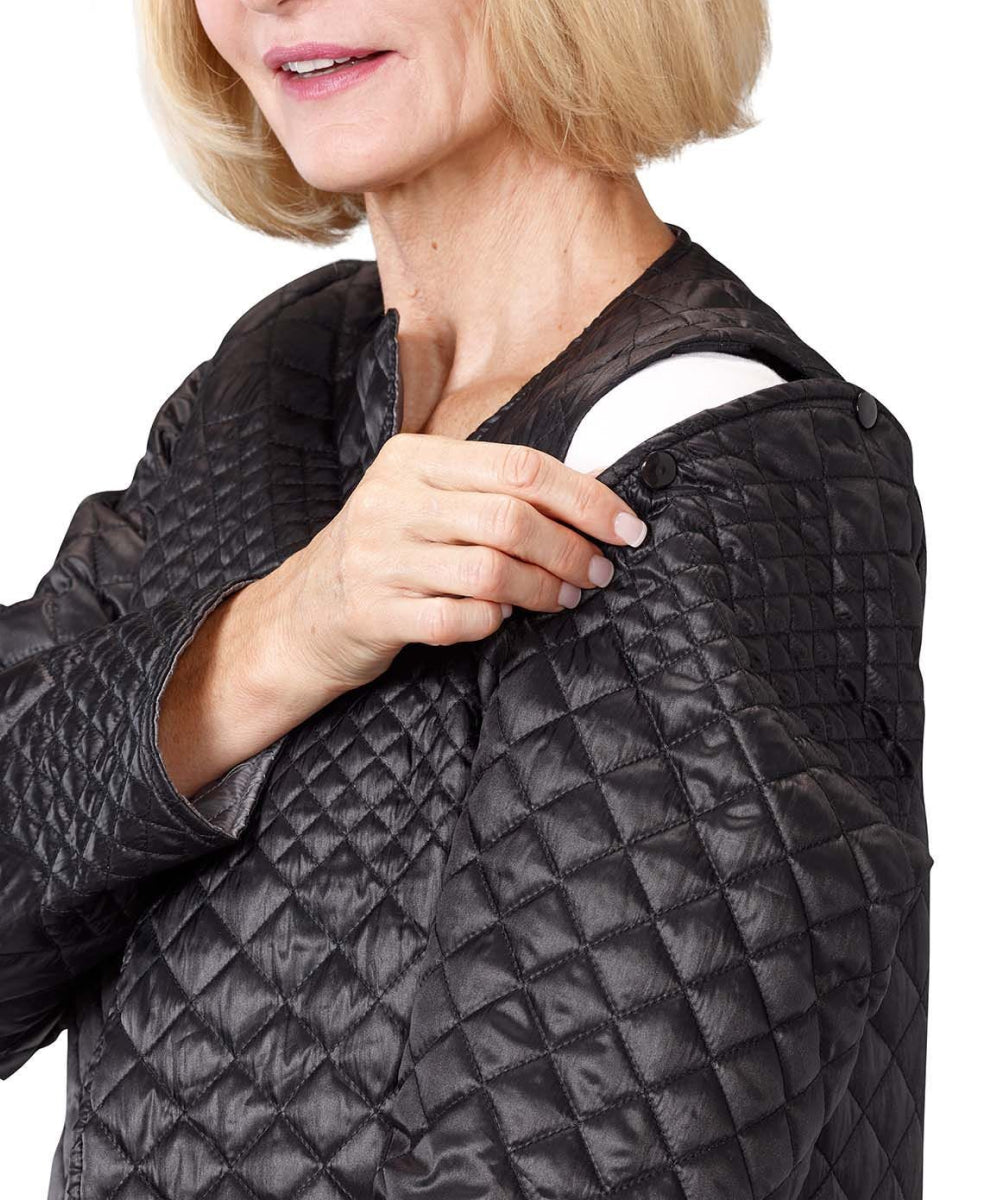 Close up of women’s black quilted reversible jacket with side seam pockets and removable sleeves.