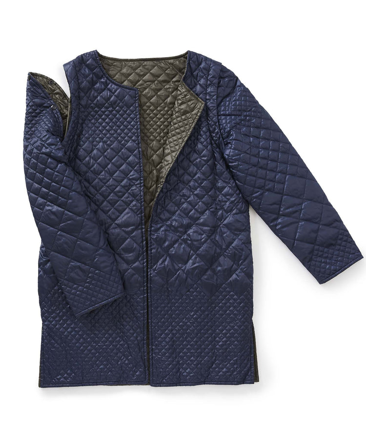 Women’s navy blue quilted reversible jacket with removable sleeves and side seam pockets.