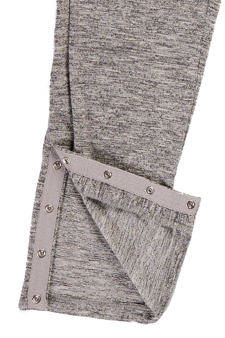 Close up view of the bottom of grey full length slim pants with ankle snap closures.