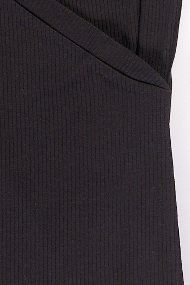 Close up of black long sleeve wrap top with side snap closures.