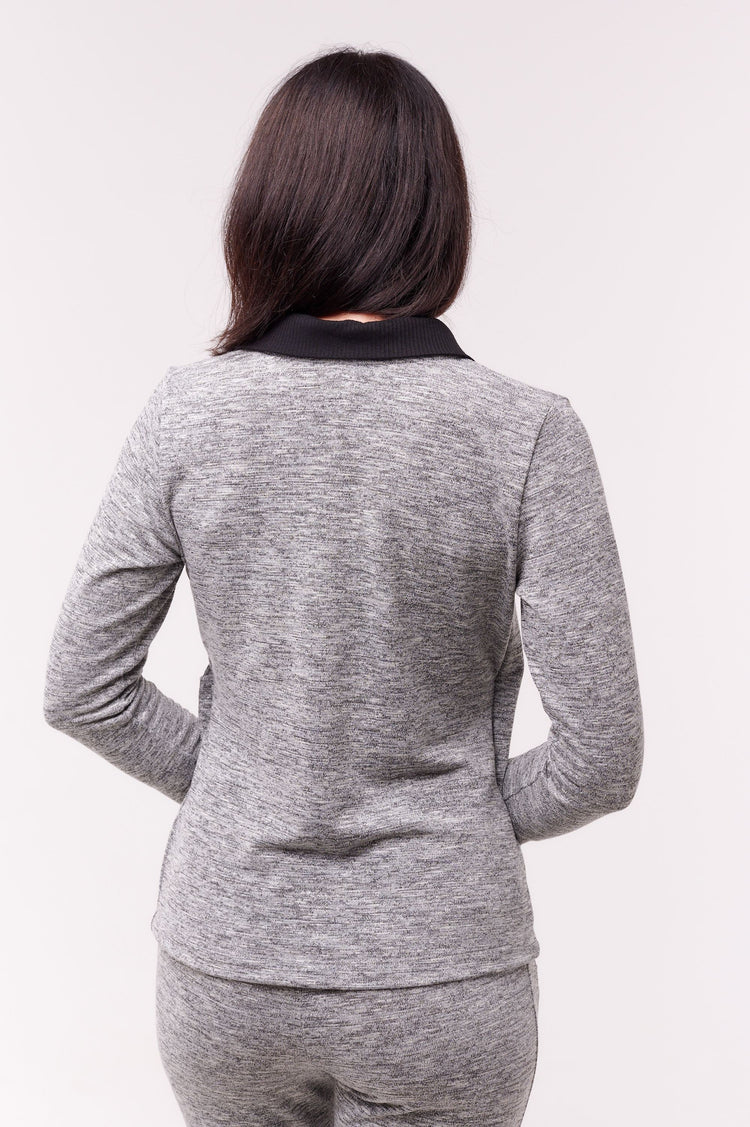 Woman facing away wearing grey long sleeve wrap top with side snap closures.