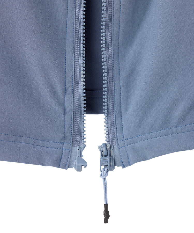 Close up of women’s light blue rain jacket with magnetic zipper.