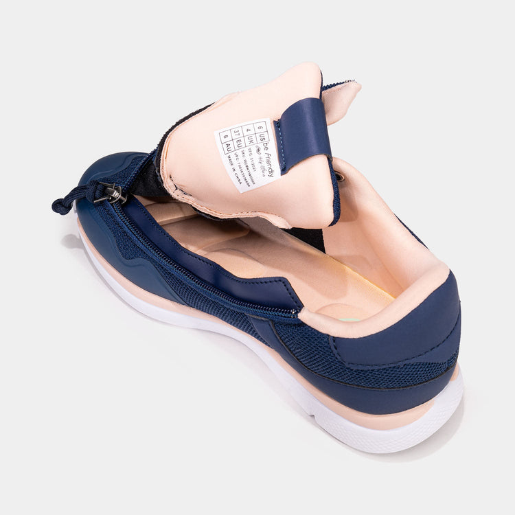 Navy women's shoe with peach accents and unzipped rear zipper access and peach interior.